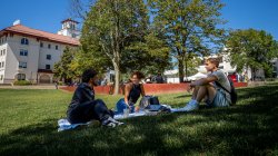 Students sitting on a blanket on the lawn at Montclair State University.