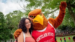 Student taking a picture with Rocky.