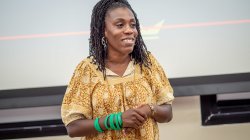 Tiffany Aliche at the front of a lecture hall speaking to an audience