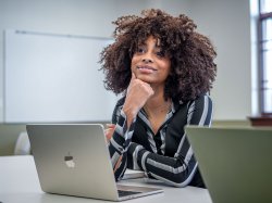 Student listening to a lecture with a smile on her face.