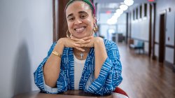 Cookie Howard sits at a table in a hallway in Susan A. Cole Hall.