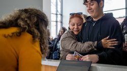 A mother hugs her son who has been accepted to Montclair State University.