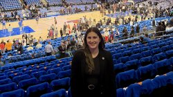 Emily Swedelson standing in the stands at Madison Square Garden with the court in the background.