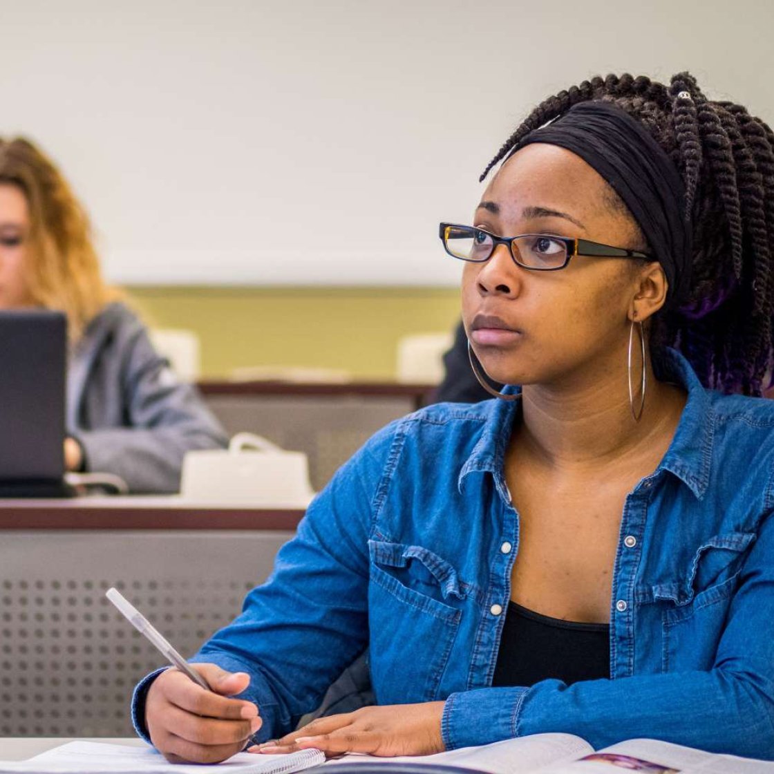 Student taking notes in class.