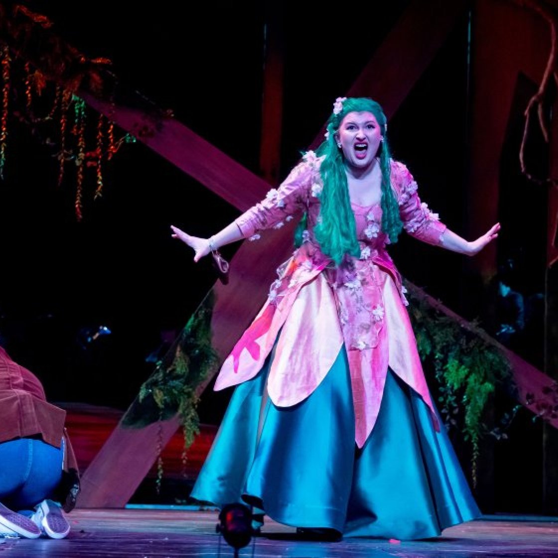 Student singing on stage in production of "Into the Woods"