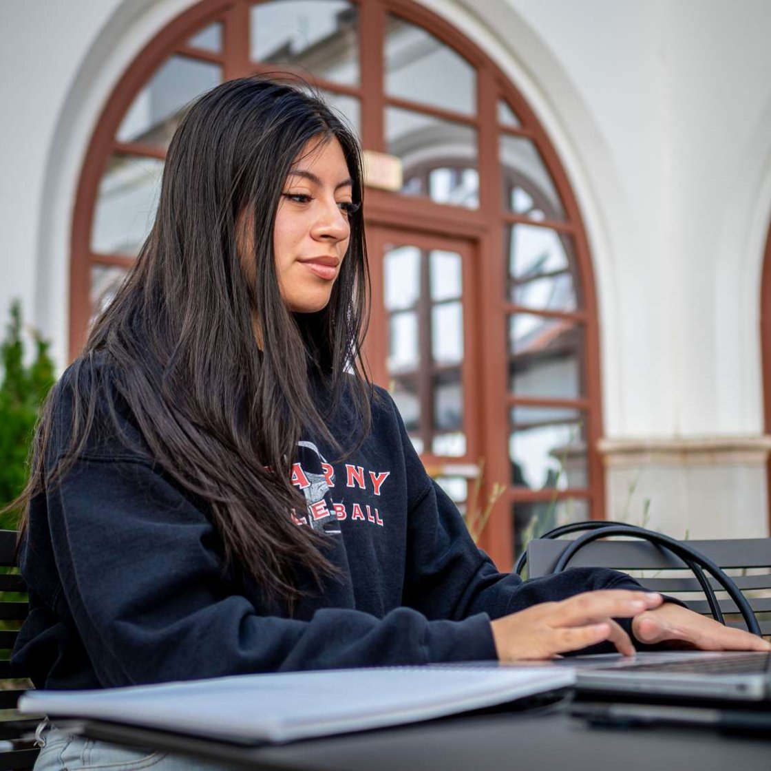 Montclair State University student working on a laptop outside.