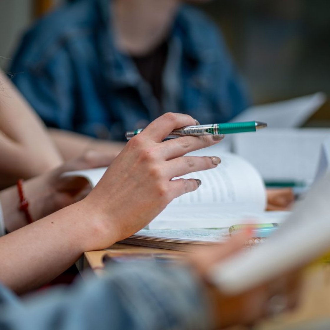 Photo of a student hands taking notes.