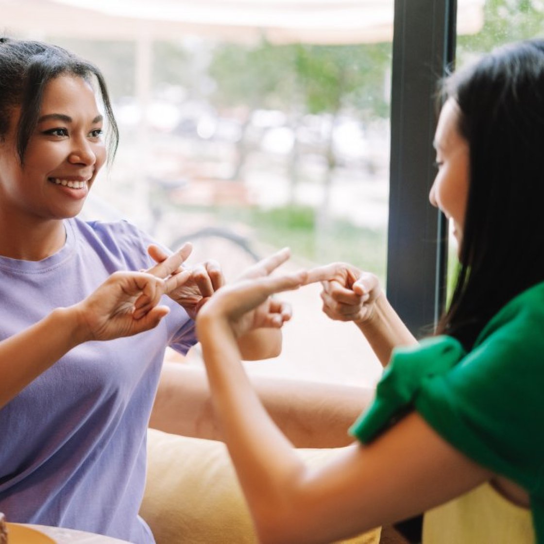 Two students practicing sign laungage together.