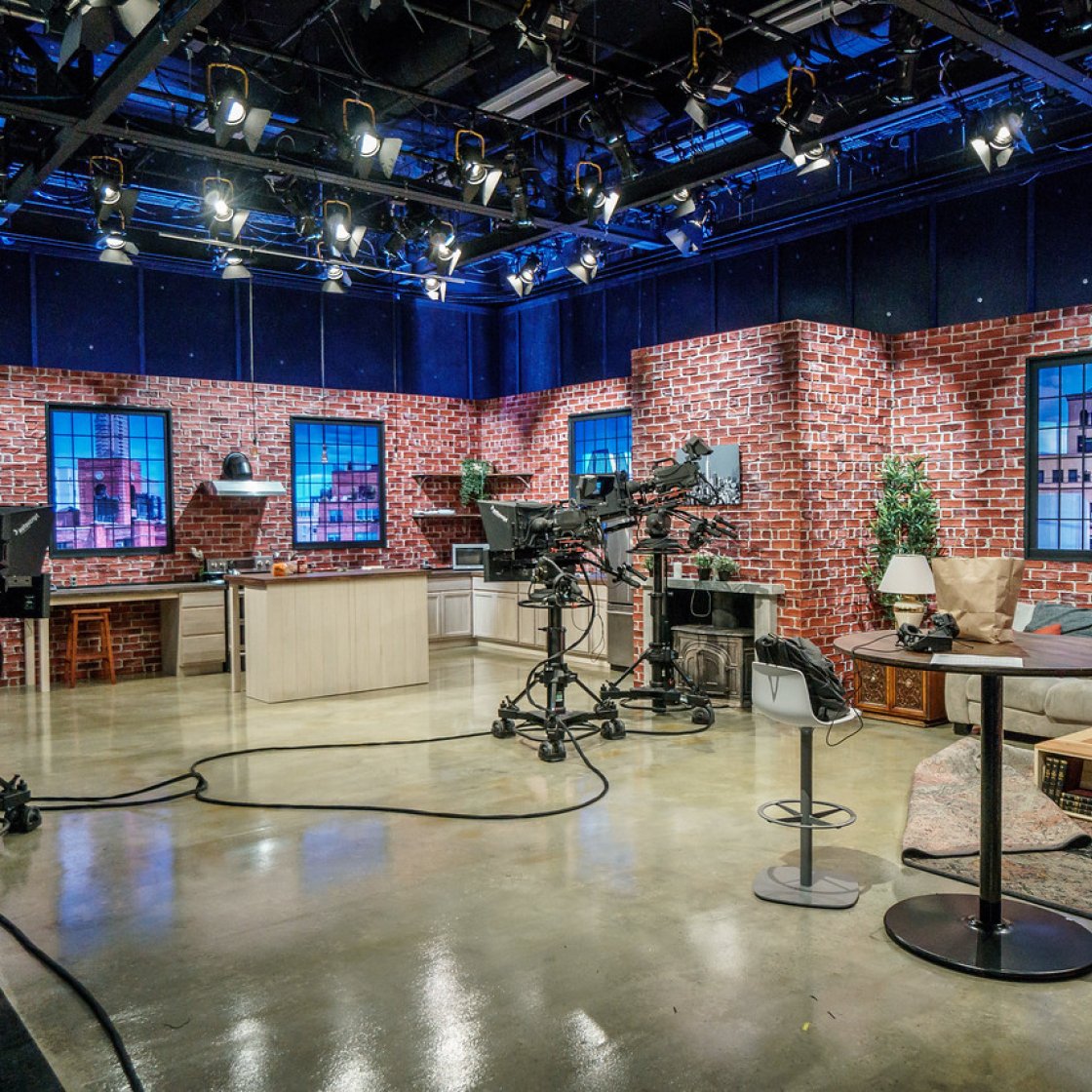 The interior of a television studio with lights and cameras.