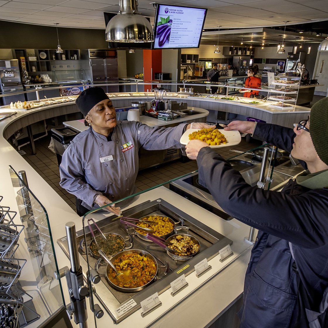 Student receiving food at Sams Place over the counter. 