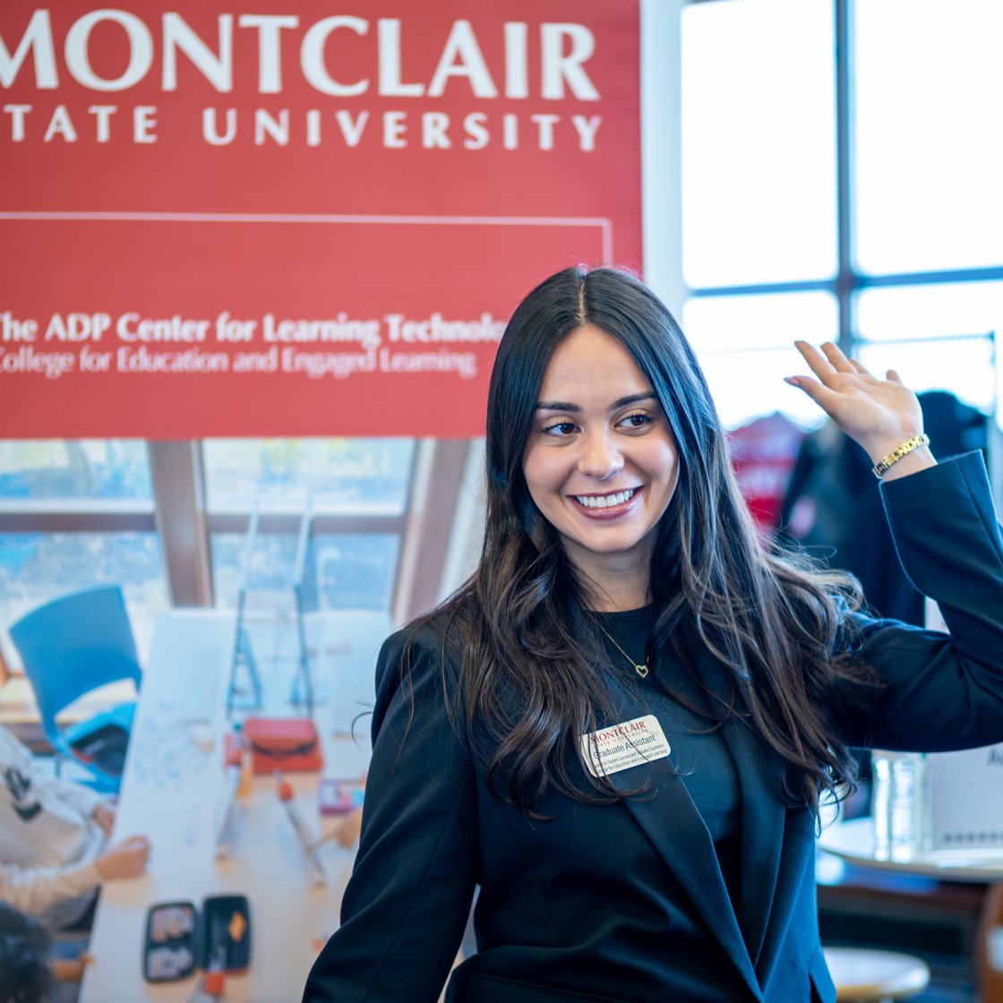 Female students is smiling while raising her hand.