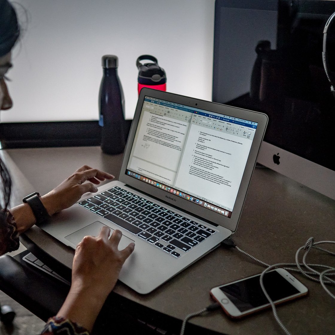 Female student using a mousepad on laptop.
