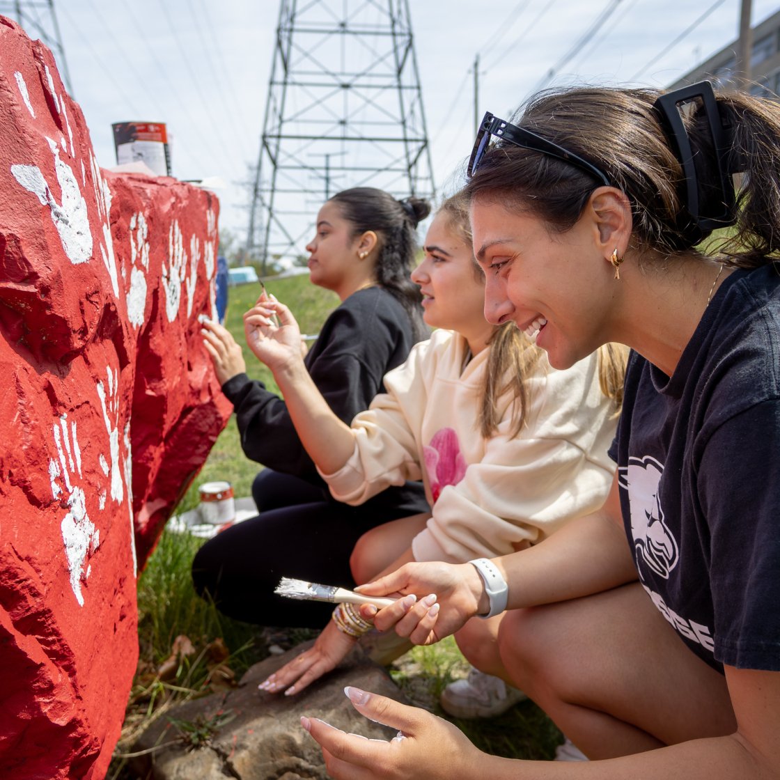 Students painting a rock.