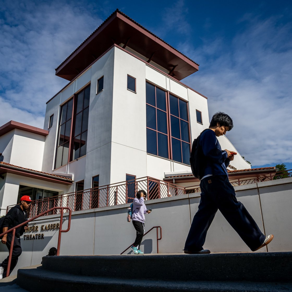 Students climbing stairs or walking in front of the Kasser Theater.