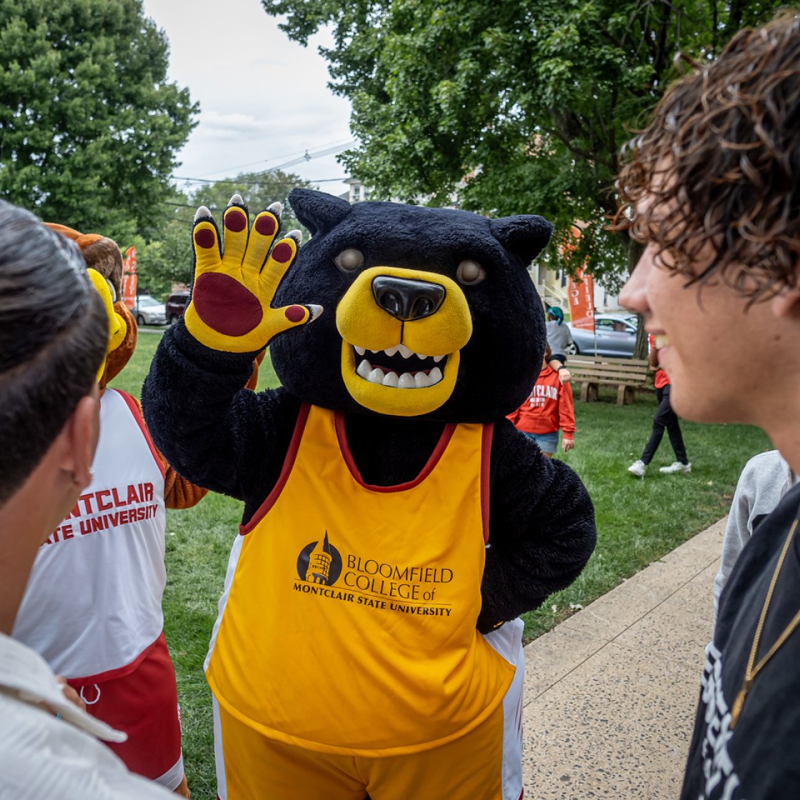 Deacon waving to students on campus.