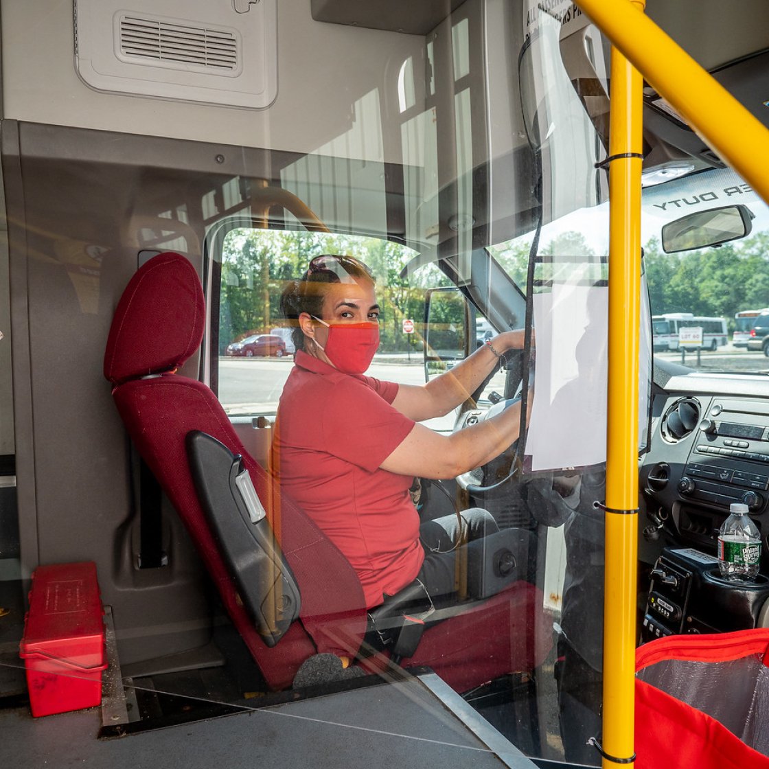Female driver driving a shuttle bus.