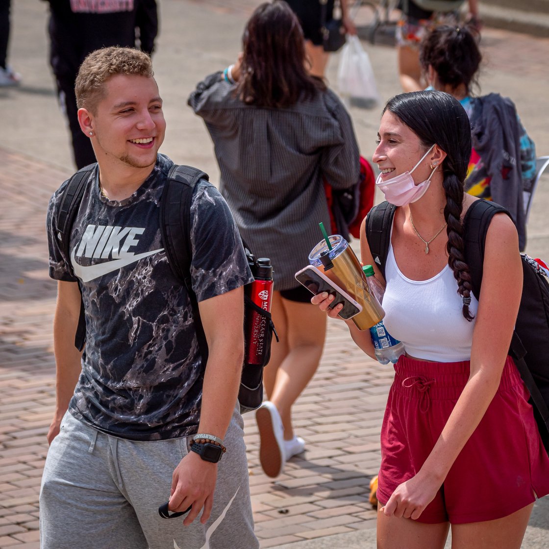 Two students at a Student Involvement Fair conversing.