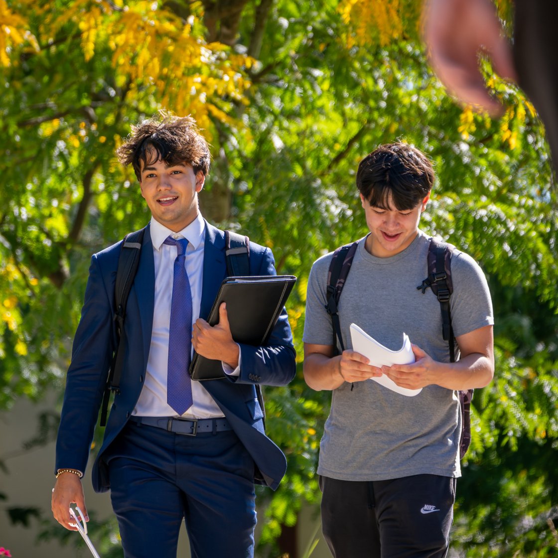 Two students walking around campus in the summer.