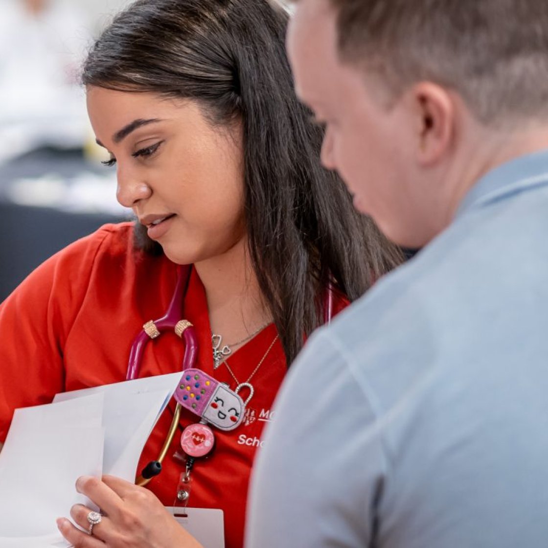 Nurse looking over papers with someone else.
