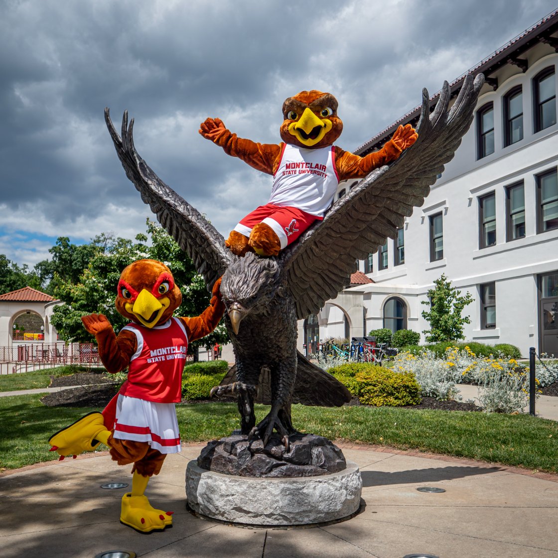 Rocky and Roxy posing, while Rocky is on the Hawk statue.