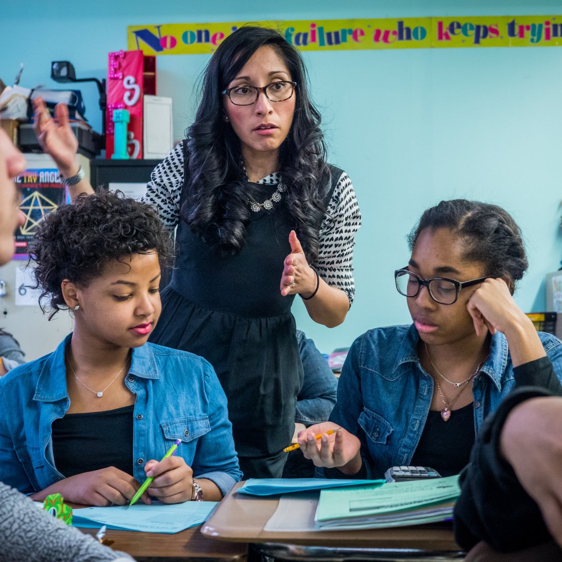 Teacher in a classroom explaining to students.