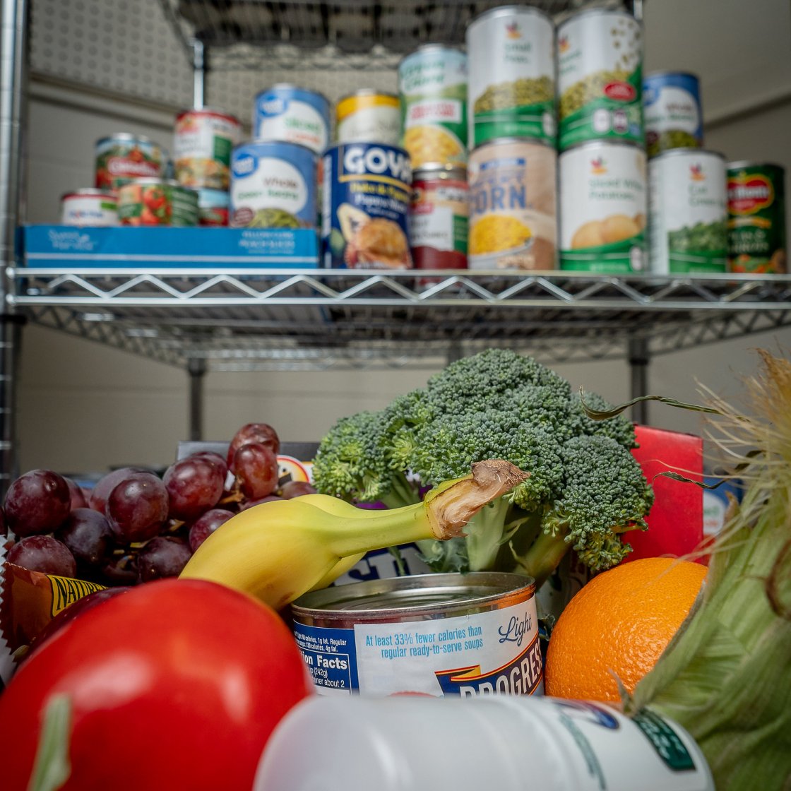 Food pantry full of food cans, fruits, and vegetables.