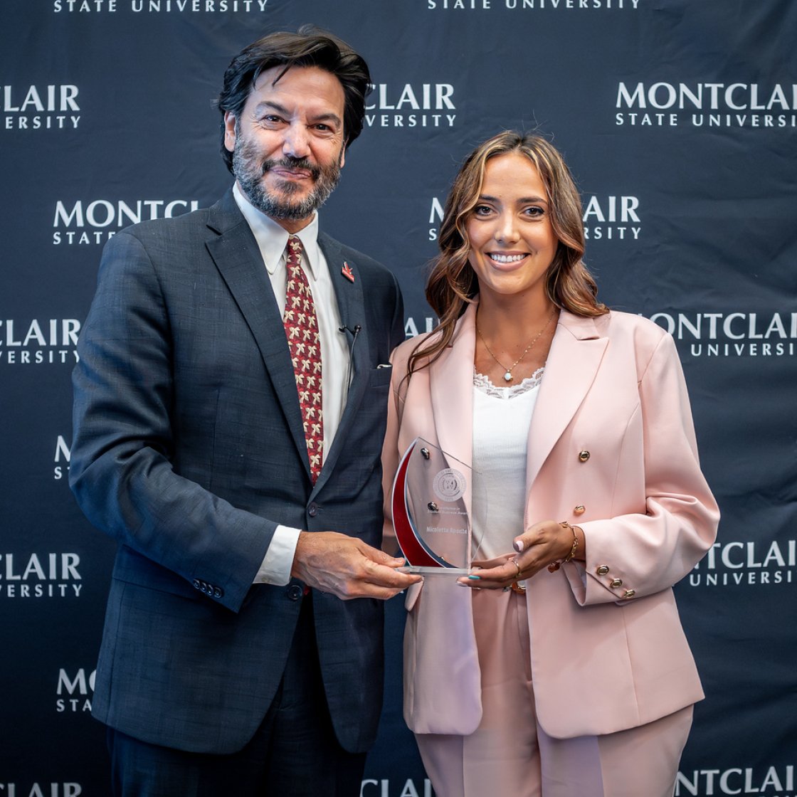 Man is posing with a woman holding a Presidential Excellence Award.