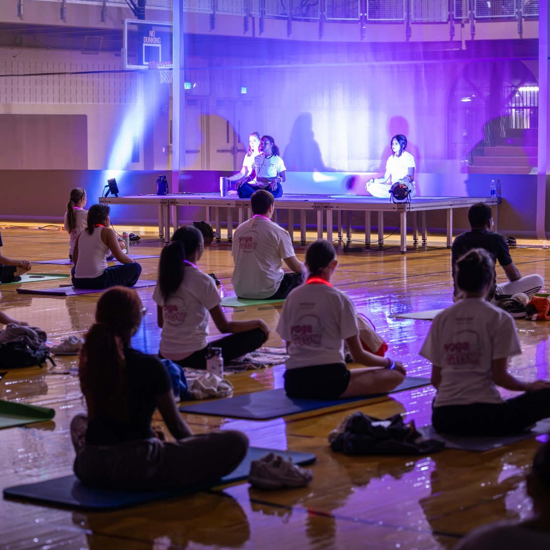 Glow yoga studio filled with students in poses.