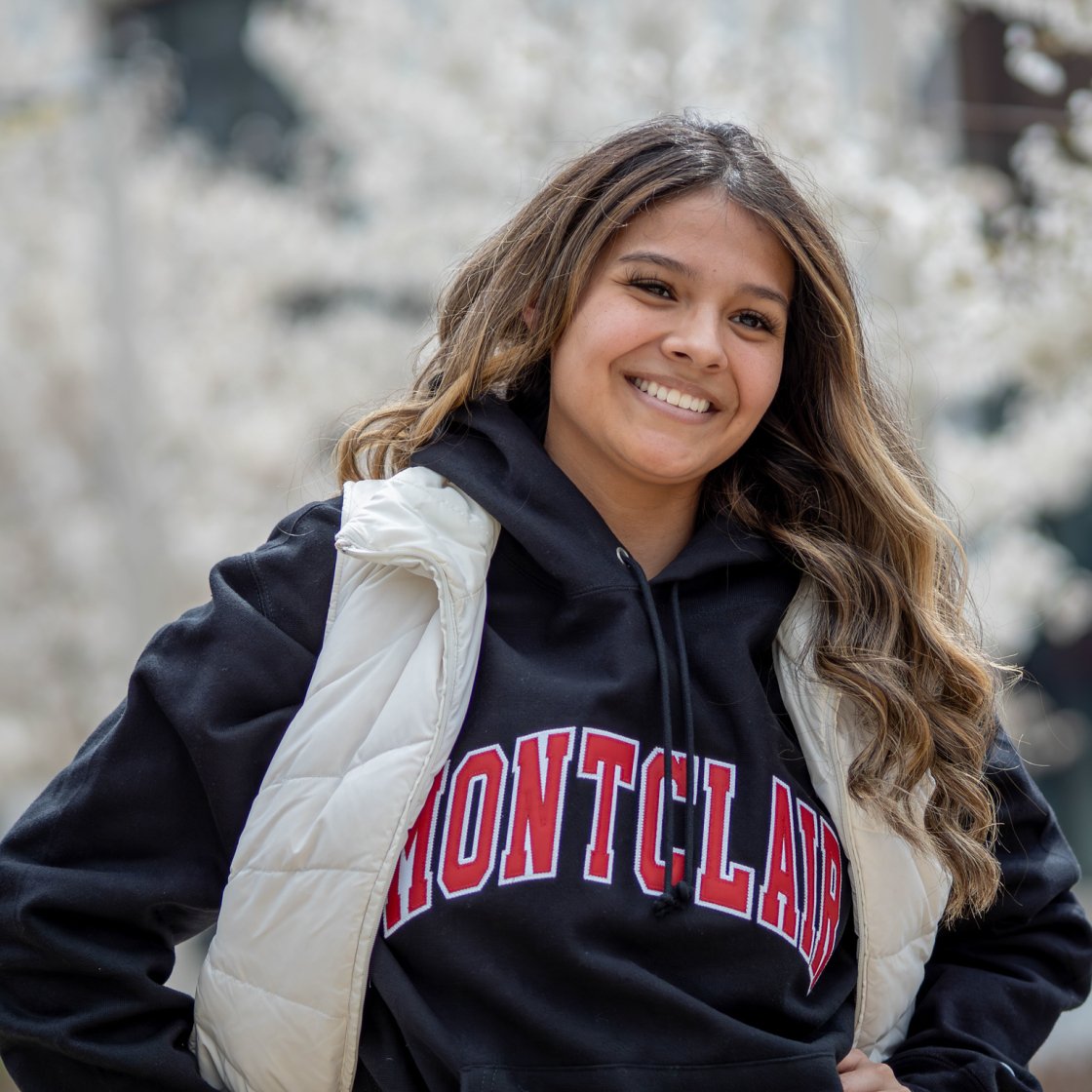 A student smiles brightly wearing a Montclair sweatshirt.