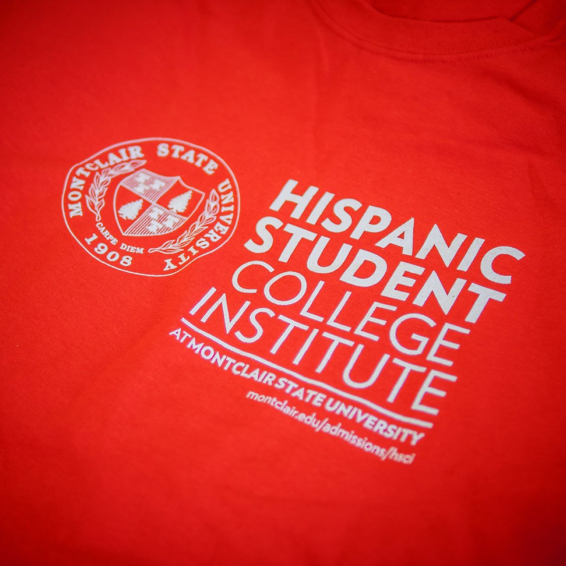 Red tshirt with the Hispanic Student College Institute words and logo in white.