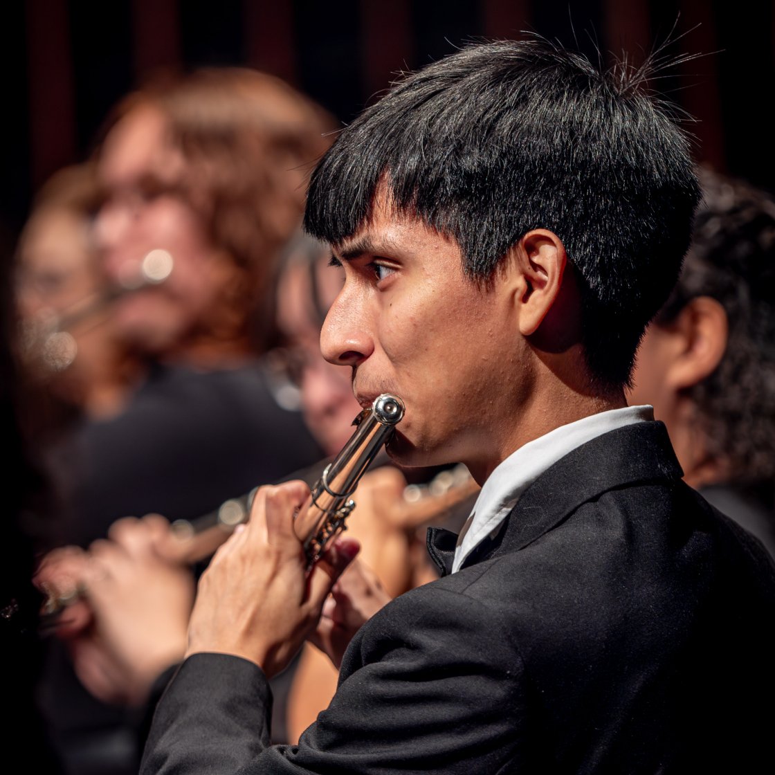 Student on stage playing an instrument.