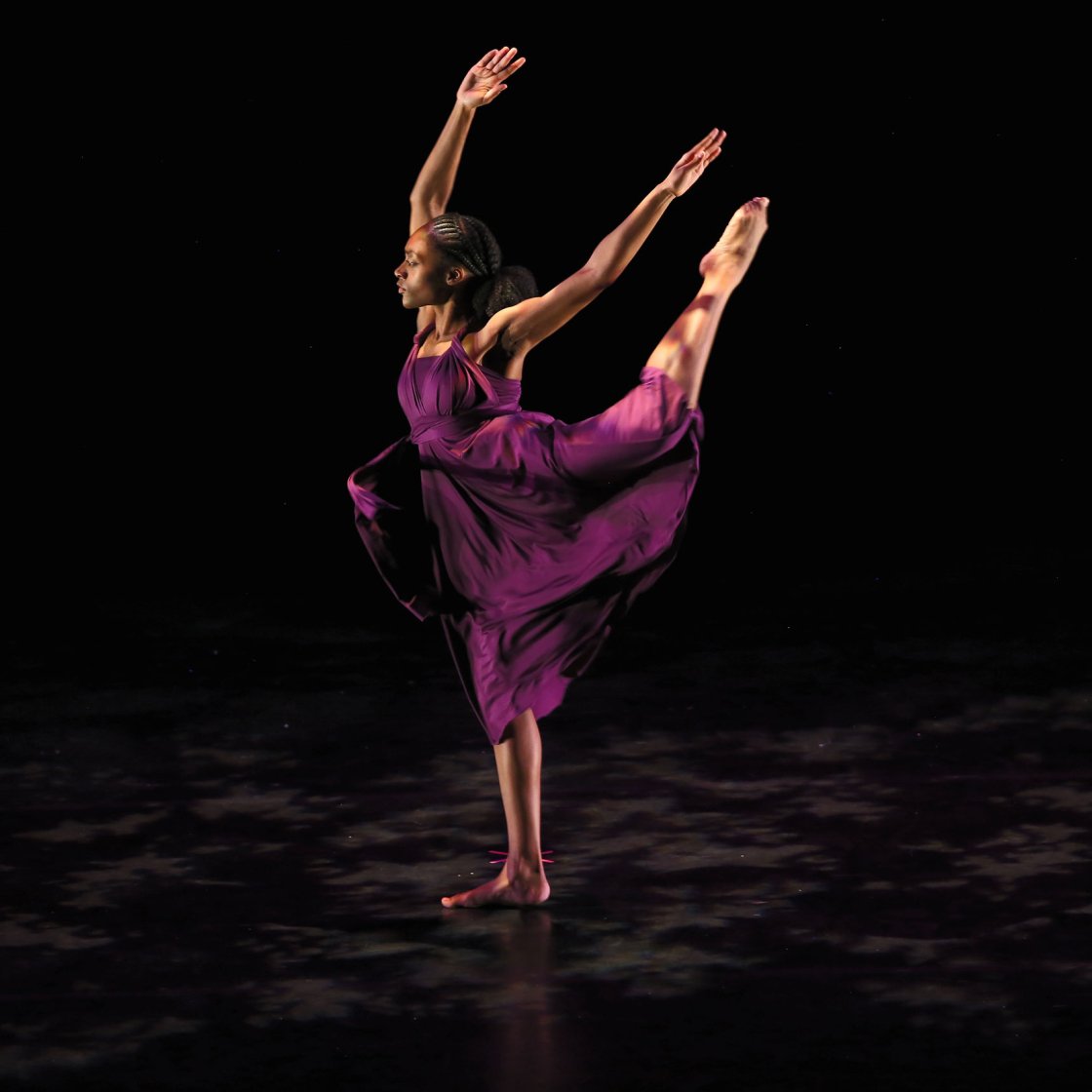 Dance student on stage wearing flowing purple dress