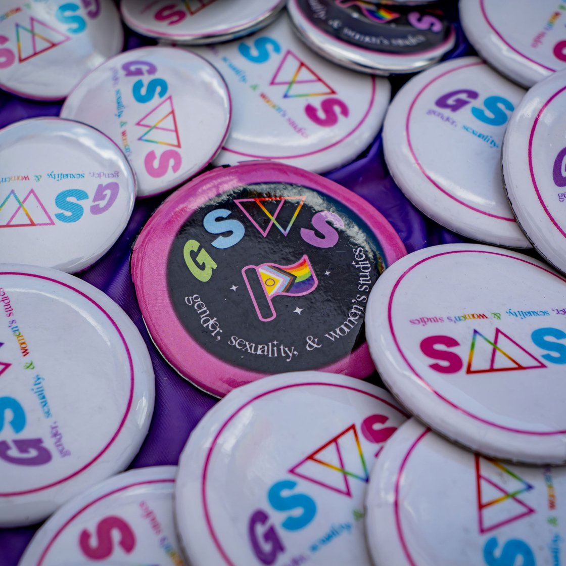 Pile of buttons that say GSWS for Gender Sexuality and Women's Studies
