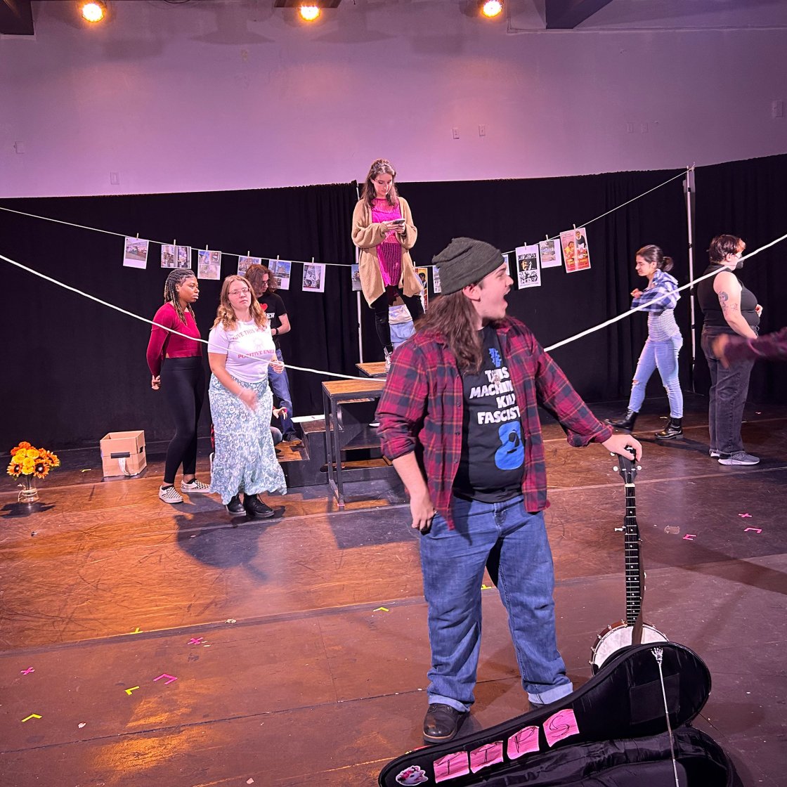 students on stage, holding string to lay out a set