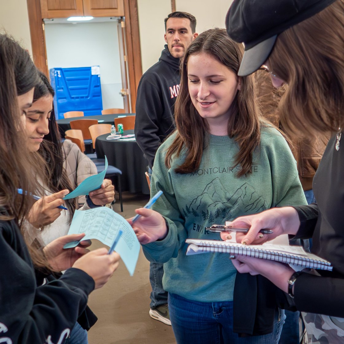Students writing stuff down at a Networking Event conversing.