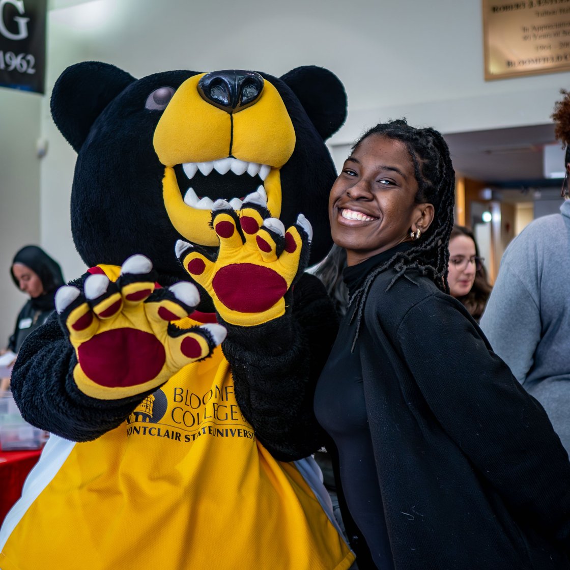 Deacon the Bear poses with student