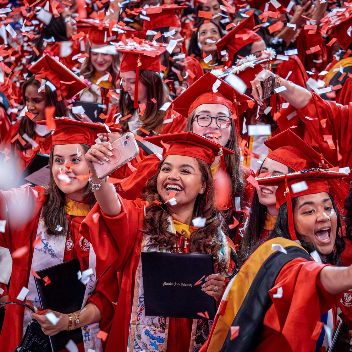 graduate students at commencement with confetti falling