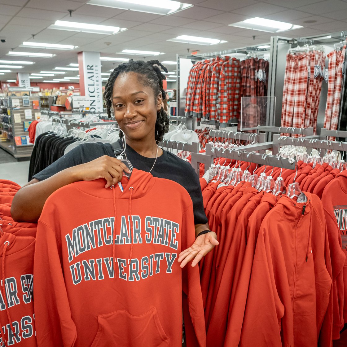 Student holding up a Montclair State University hoodie