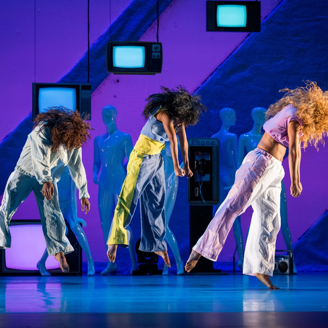 dancers on stage mid-jump
