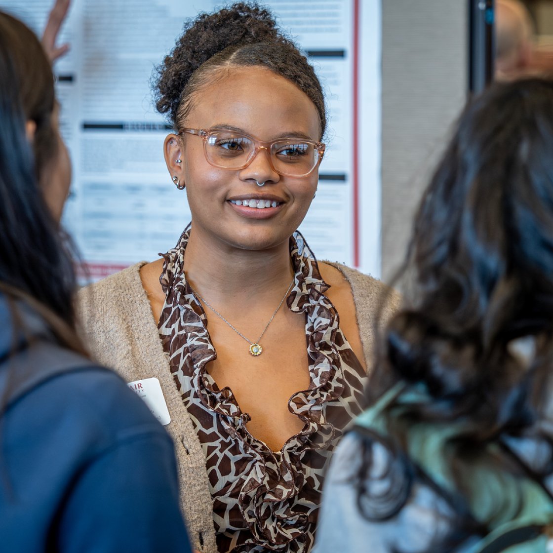 Student researcher discussing healthcare data analysis findings during a Montclair State University research symposium.