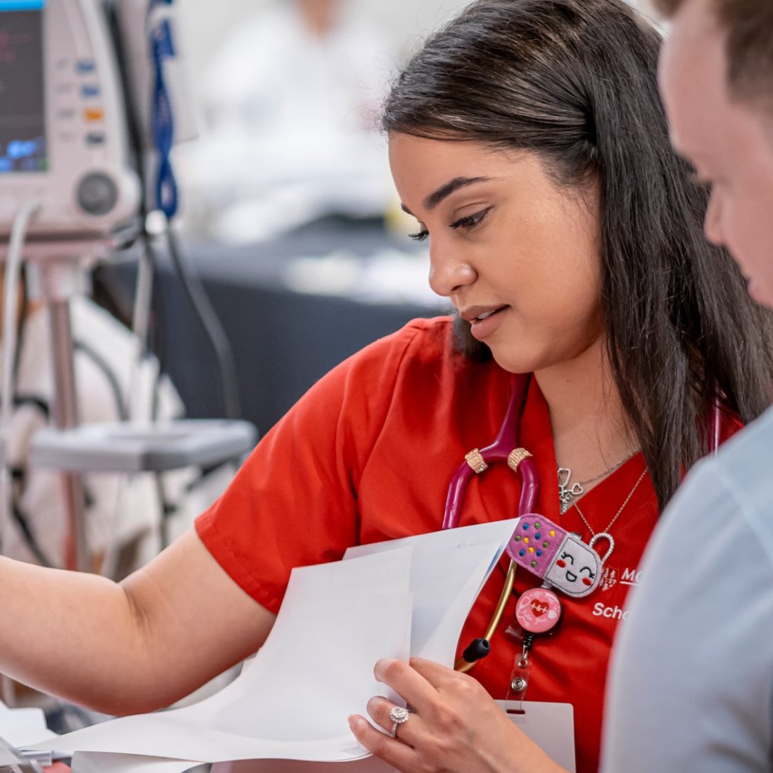 Nursing student works with an instructor during a clinical learning experience