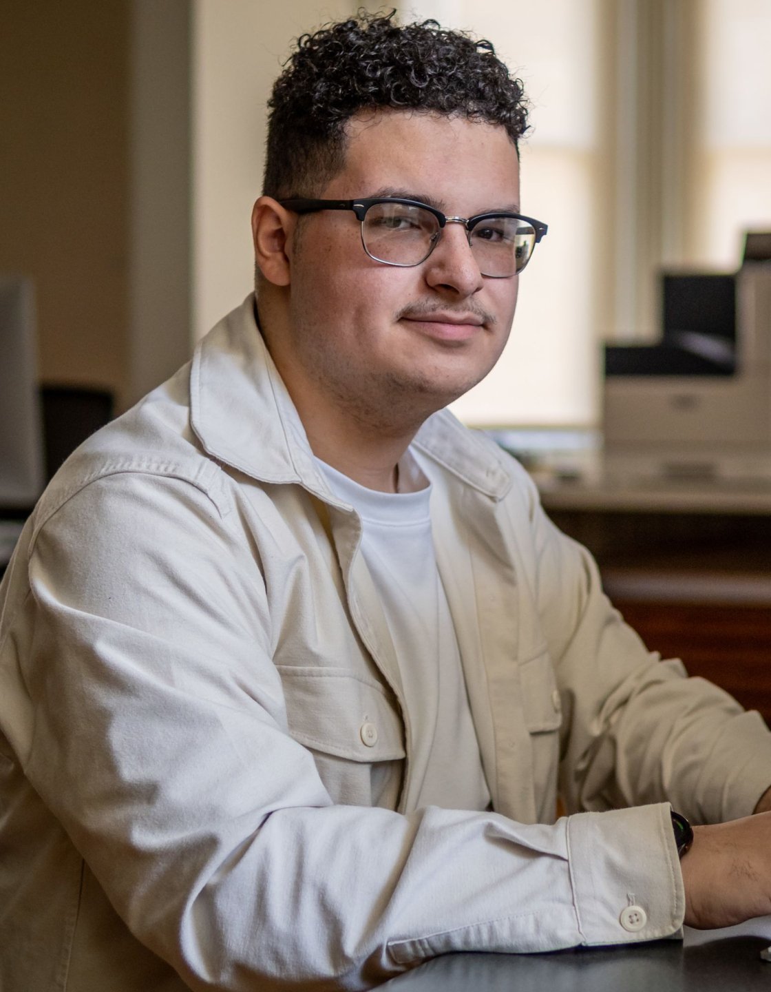 Abraham Rubio smiling at the camera, his hands rested on a keyboard.