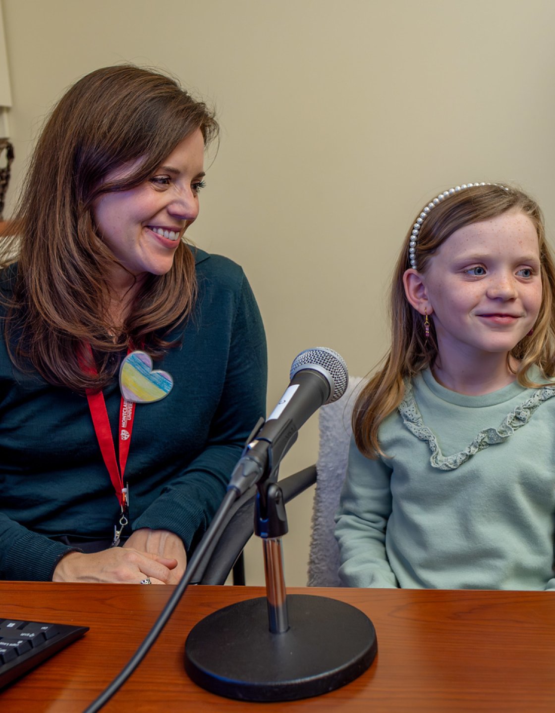 Professor and student in speech lab in front of a microphone. 