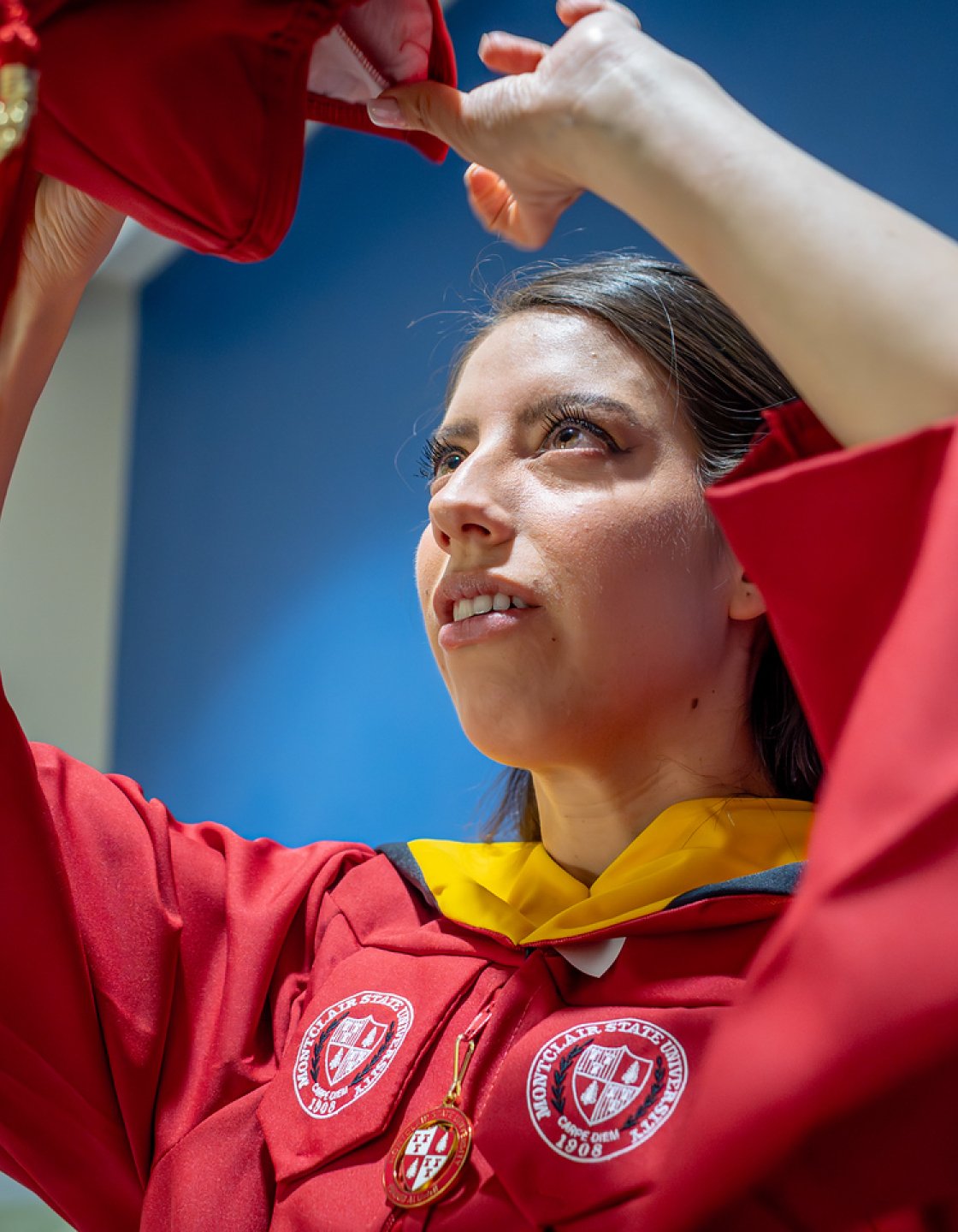 Andrea Uguna-Solano putting on her mortarboard.
