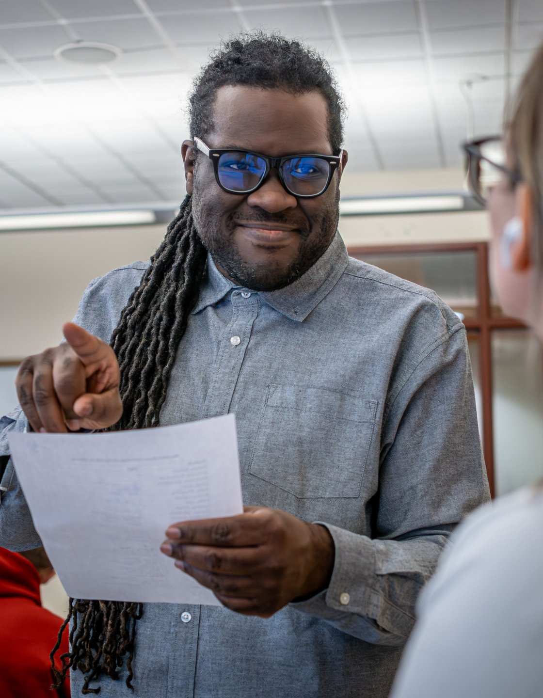 Professor Jason Williams in class having a one-on-one conversation with a student