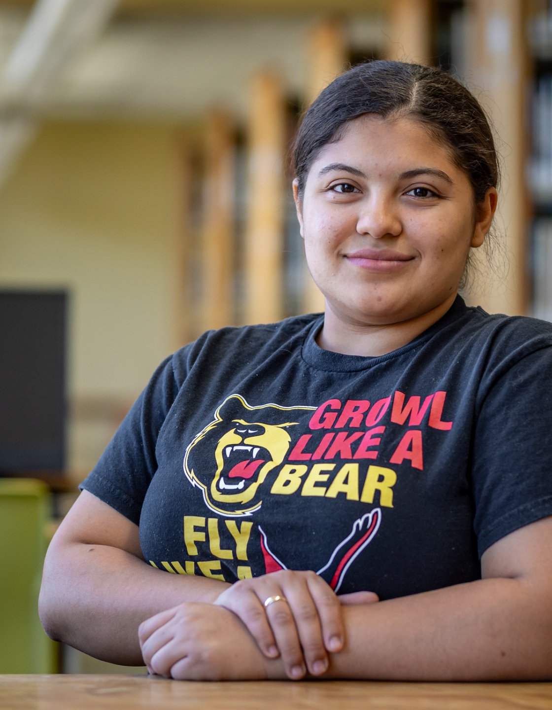 Odyeli Ramos Tobar sits at a table in the campus library.