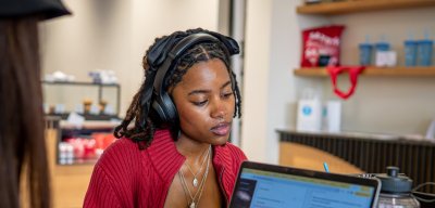 Female student is on her laptop with headphones on.