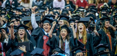 Group of graduates celebrating at commencement with their cap and gown.