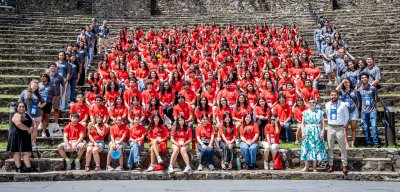 Students and staff of the HSCI sitting on the Amphitheater as their picture is taken.