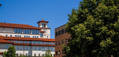 Photo of University Hall outside. Calcia hall can also be seen from behind a few trees.